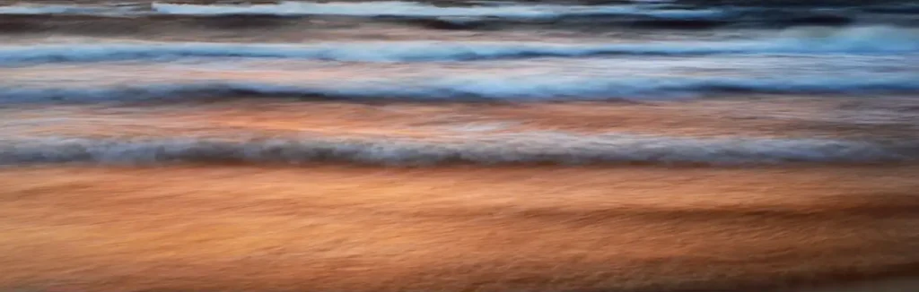A blurry image of the ocean and sand.