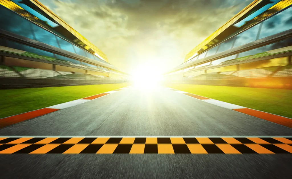 A race track with the sun shining in the background.