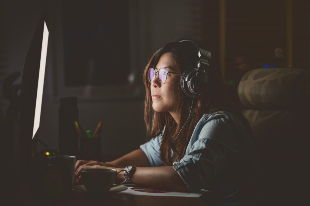 Woman with headphones working at computer.