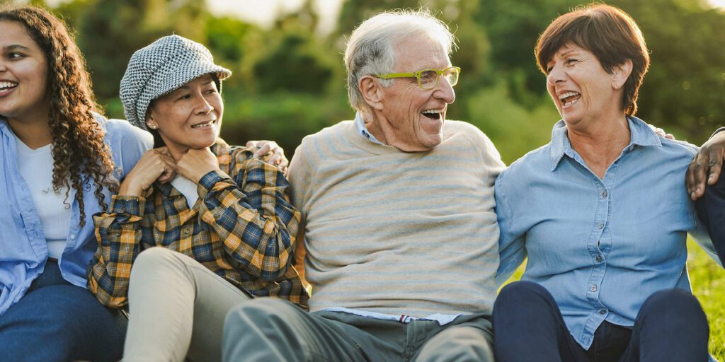 Group of people laughing outdoors together.