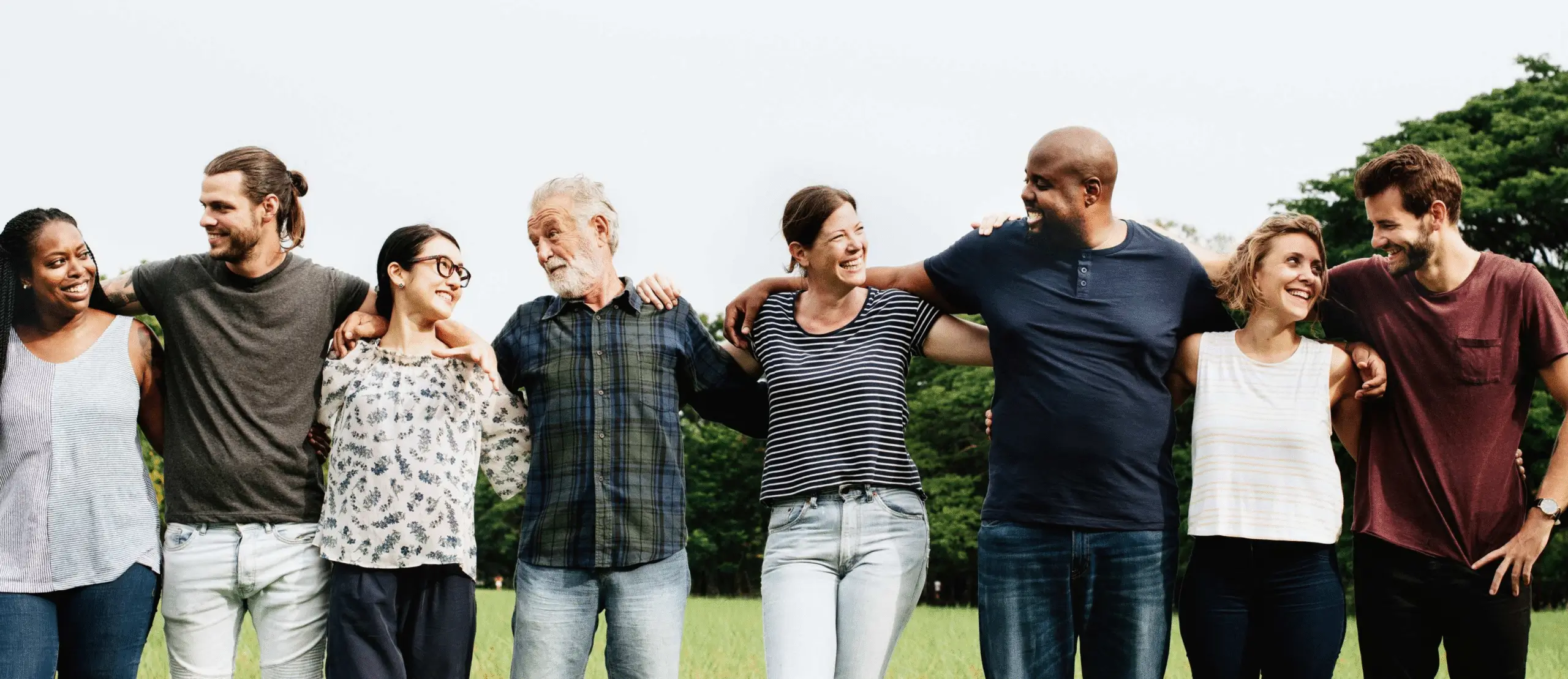 Diverse group of people standing together outdoors.