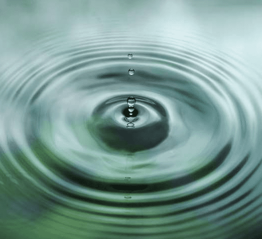 Water droplet creating ripples on surface.